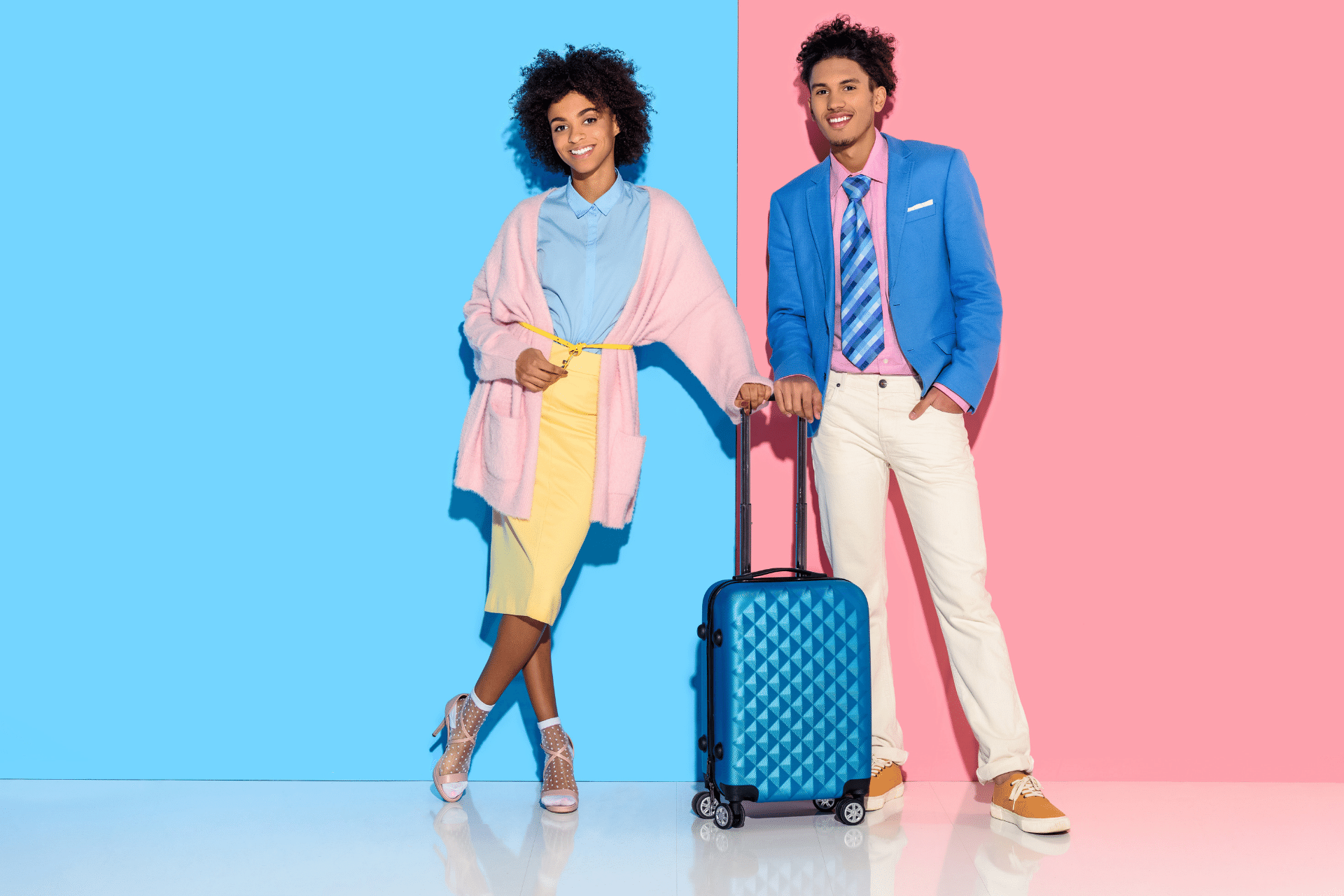 Image of a happy man and woman standing together holding a suitcase handle