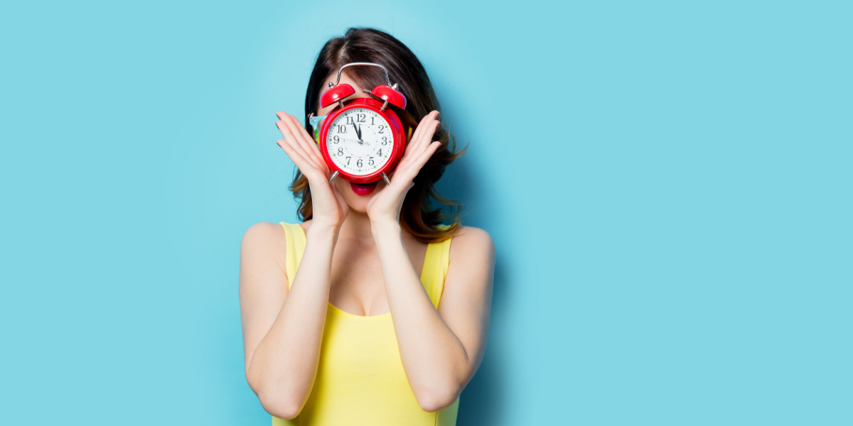 Image of a woman holding a clock in front of her face